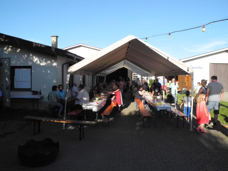 großes Zelt rechts neben der Musik-Schiire mit Festzeltbänken und Gästen