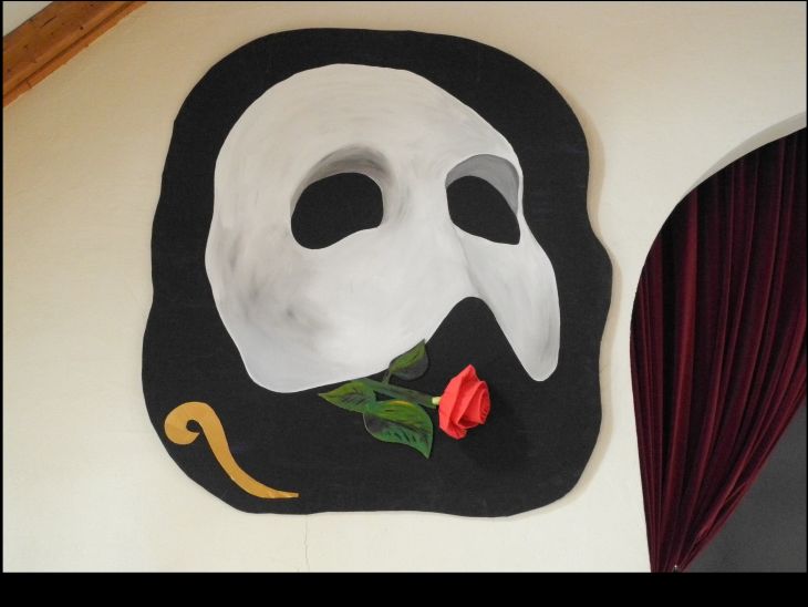 Maske des "Phantom der Oper", darunter eine rote Rose
