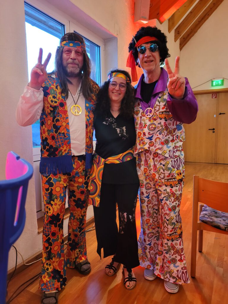 Zwei Fans im Hippi-Kostüm nehmen Susanne Schmidt in ihre Mitte